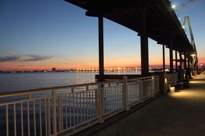 Bridge over sea against sky during sunset