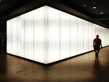 Man standing in illuminated corridor