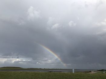 Scenic view of rainbow over land against sky