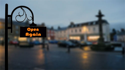 Close-up of illuminated text on street at dusk