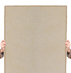 Person holding paper against white wall