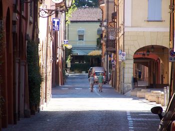 Rear view of people walking on street in city