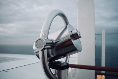 Close-up of metal railing against sea