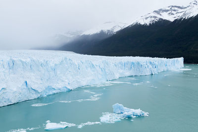 Scenic view of glacier on snowcapped mountain against sky