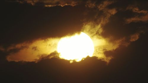 Low angle view of sun in sky during sunset