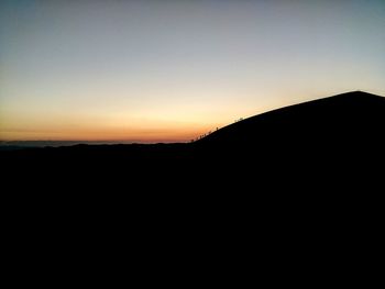 Silhouette landscape against clear sky during sunset