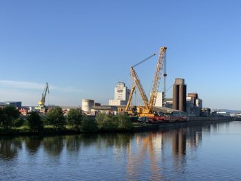 View of crane by river against sky
