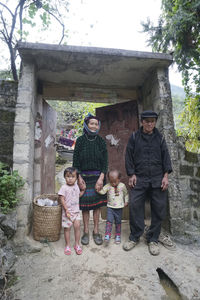 Portrait of friends standing against wall