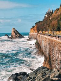 Wall by sea against sky