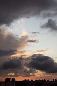 Low angle view of silhouette buildings against dramatic sky