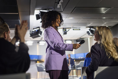 Tv show host interviewing audience member