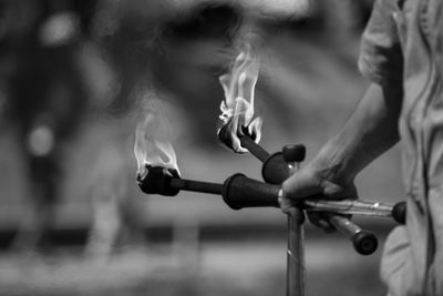 Close-up of hand holding bicycle against blurred background