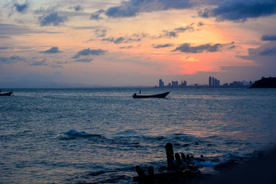 Silhouette boat in sea against sky during sunset