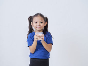 Portrait of girl standing against white background