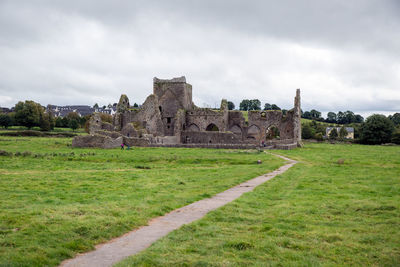 Old ruins on field against sky