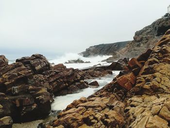 Scenic view of sea and rocks against sky