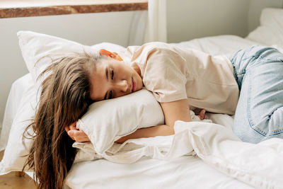 Sad bored young female brunette lies on the bed