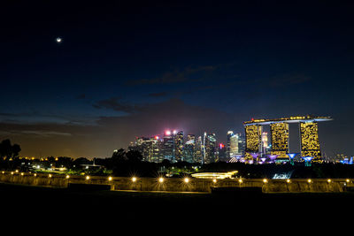 Illuminated buildings in city against sky at night