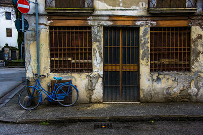 Glass door and windows with blue railing and bicycle, in vicenza, italy