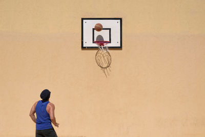 Rear view of man standing against wall