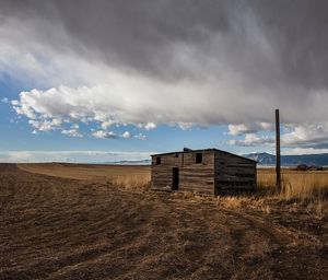 Built structure on field against cloudy sky