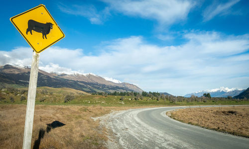 Road sign against sky