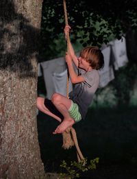 Full length of boy swinging on rope