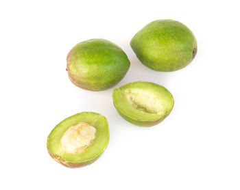 Close-up of green fruits against white background