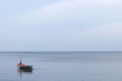 Fishing boat in sea against sky