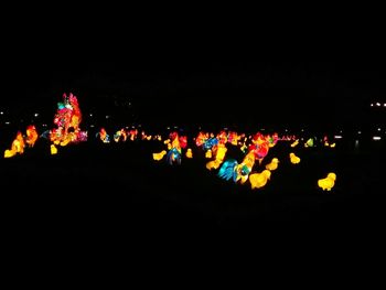 Low angle view of illuminated lights against sky at night