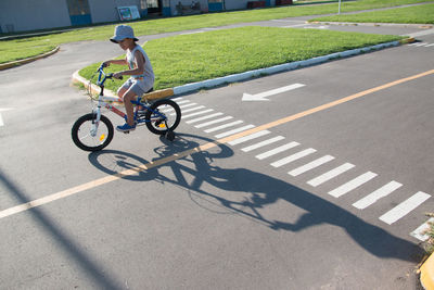 Cute boy riding bicycle on road