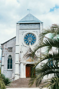 Low angle view of palm trees and building against sky