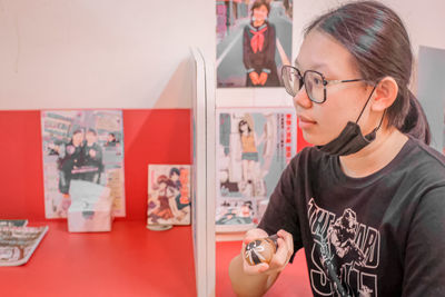 Portrait of young woman using mobile phone in office