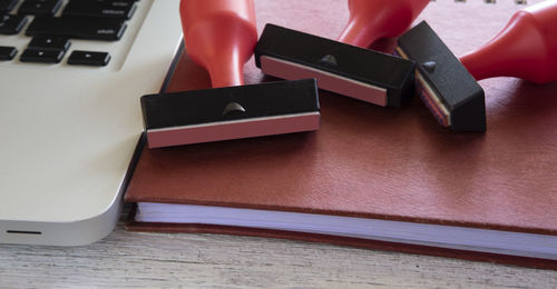 Close-up high angle view of rubber stamps by laptop on book