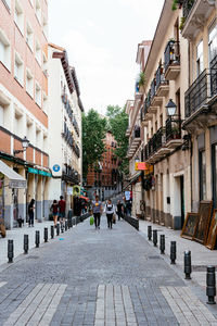 People on street amidst buildings in city