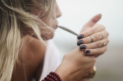 Side view of woman smoking marijuana joint