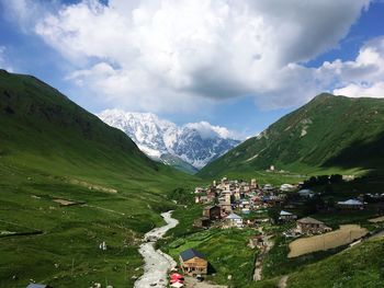 Scenic view of mountains and houses against sky