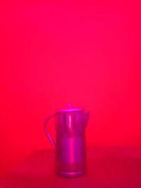 Close-up of drink in glass on table against red background