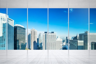 Modern buildings in city against blue sky