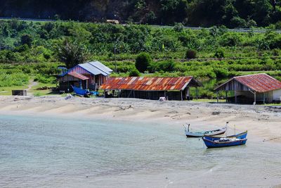 Boat moored at beach against sky