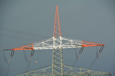 High section of electricity pylon against clear sky