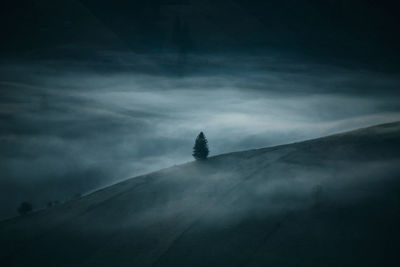 Silhouette of mountain against cloudy sky