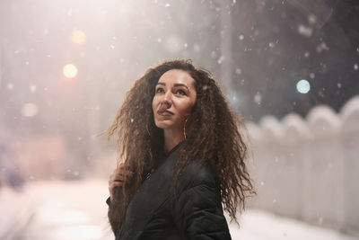 Portrait of young woman in snow during winter