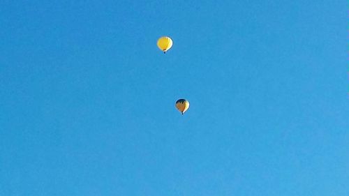 Low angle view of hot air balloons against blue sky