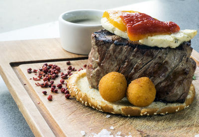 Close-up of fresh filet mignon steak with brynza and mushroom sauce on wooden cutting board