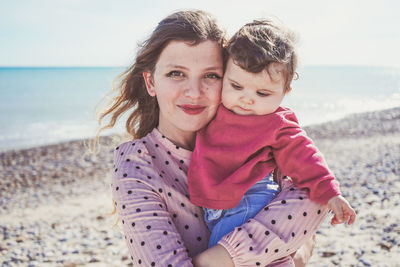 Portrait of mother with daughter on beach