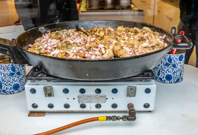 Close up of champignons and bacon being fried in front of a dirty glass shop window