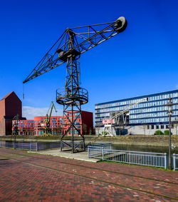 Low angle view of crane against sky
