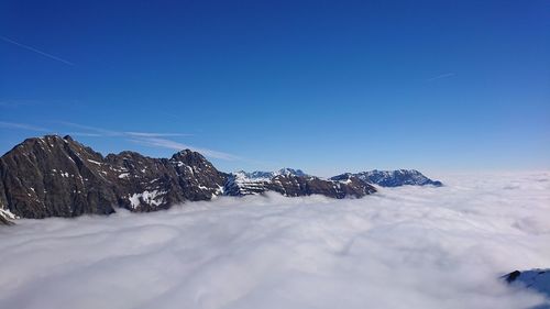 Scenic view of snowcapped mountains against clear blue sky