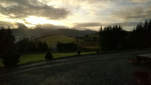 Scenic view of field against sky at sunset